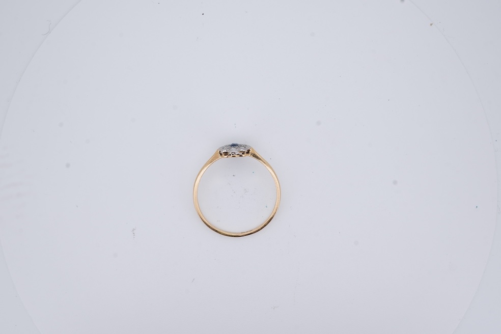 A 1920's yellow metal, stamped 18ct, sapphire and diamond set oval cluster ring, size V, gross weight 2.3 grams. Condition - poor to fair